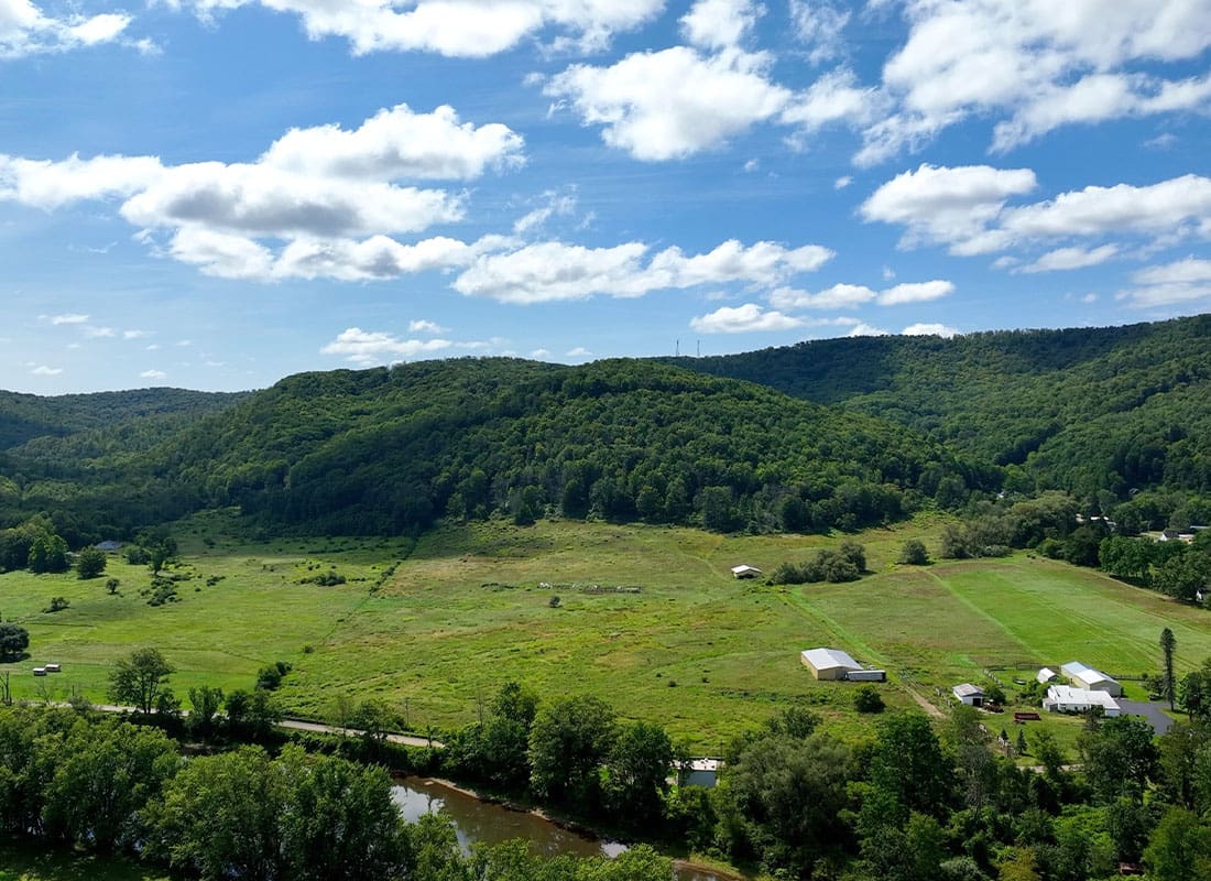 DeRuyter, NY - Aerial View of Rural Fields and Mountains in the Background